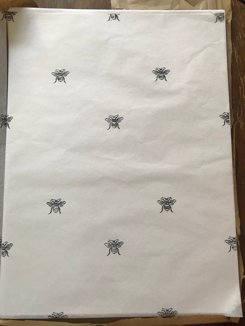 May include: White tissue paper with a repeating pattern of black bee silhouettes.