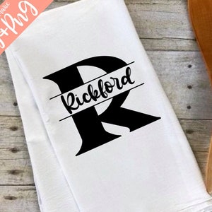 May include: White kitchen towel with a black letter R and the name "Rickford" written across the top of the letter.