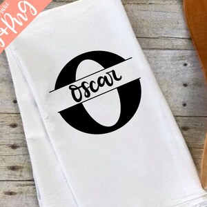 May include: White kitchen towel with a black letter O and the name Oscar written across the center of the letter.