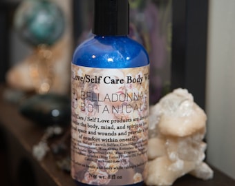 May include: A blue bottle of body wash with a white label that reads "Love/Self Care Body Wash Bella Donna's Botanicals". The label also includes a description of the product and its ingredients. The bottle is 8 fl oz.