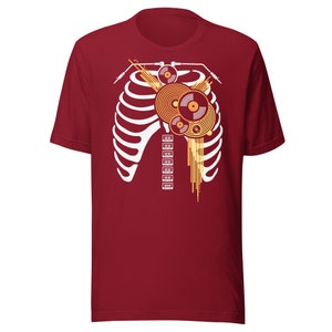May include: Red t-shirt featuring a white ribcage design with a colourful record player inside the ribcage.