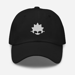 May include: Black baseball cap featuring a white embroidered face design. The cap has a curved peak and an adjustable strap. A simple, everyday accessory.