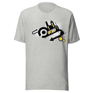 May include: A grey t-shirt with a black and yellow graphic design featuring a stylised cityscape with a circle and arrow.