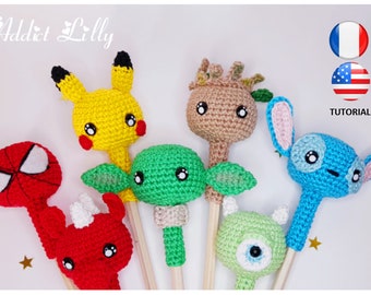 Może przedstawiać: Sześć postaci wykonanych na szydełku na drewnianych patyczkach. Postacie to Pikachu, Groot, Stitch, Spiderman, Yoda i Mike Wazowski. Figurki są wszystkie w jasnych kolorach i mają duże, wyraziste oczy.