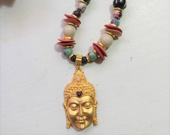 Short necklace with Buddha head pendant, ceramic beads, marble, lava, garnets and carved bone.