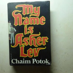 May include: A hardcover book with a black cover featuring the title "My Name is Asher Lev" in large, stylized red and yellow lettering. The author's name, Chaim Potok, is printed at the bottom. An illustration of a person painting is on the left.