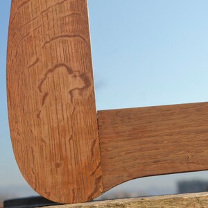May include: Close-up of a wooden corner joint, showing the grain of the wood and the way the pieces are joined together. The wood is a rich brown color.