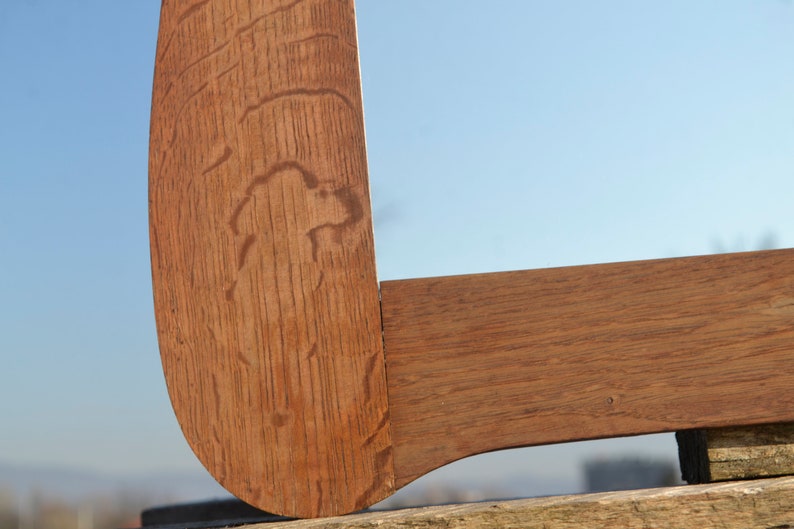 May include: Close-up of a wooden corner joint, showing the grain of the wood and the way the pieces are joined together. The wood is a rich brown color.