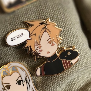 May include: Enamel pins with anime-style characters. One pin shows a character with blonde hair and a speech bubble saying "GET HELP." Another pin depicts a character with long silver hair and a gold wing. The pins are on a textured green surface.