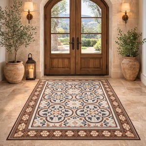 May include: A rectangular floor mat with a brown border and a repeating floral design in cream, blue, and brown. The mat is placed in front of a set of wooden double doors.