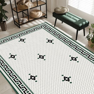 May include: A black and green patterned rug with a geometric border. The rug has a white background with green and black diamond shapes.