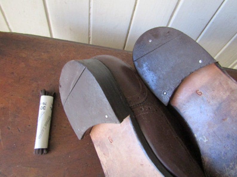Puede incluir: Primer plano de un par de zapatos de cuero marr&oacute;n con dise&ntilde;o de brogue. Los zapatos tienen una suela de cuero marr&oacute;n oscuro y est&aacute;n en buen estado.