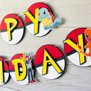 K&ouml;nnte beinhalten: Ein dekoratives Banner mit der Aufschrift HAPPY BIRTHDAY, bei dem jeder Buchstabe auf einem kreisf&ouml;rmigen rot-wei&szlig;-schwarzen Pok&eacute;ball-Design montiert ist. Das Banner zeigt bunte Ausschnitte verschiedener Pok&eacute;mon-Figuren und einen Trainer.