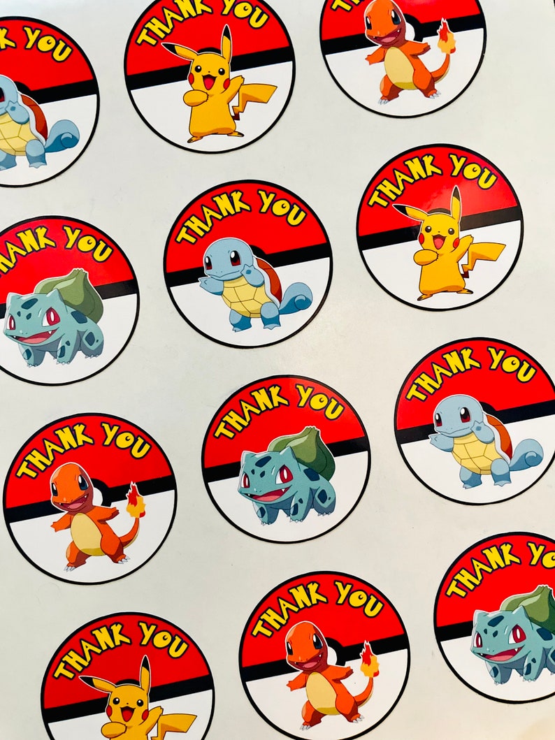 K&ouml;nnte beinhalten: Eine Sammlung runder Aufkleber mit verschiedenen Zeichentrickfiguren wie Pikachu, Glumanda, Schiggy und Bisasam. Jeder Aufkleber hat einen rot-wei&szlig;en Hintergrund, der an einen Ball erinnert, mit dem gelben Schriftzug THANK YOU.