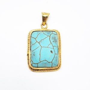 May include: A rectangular pendant with a gold-colored frame and bail. The pendant features a light blue stone with a cracked pattern. The gold frame has a textured design. The pendant is displayed against a white background.