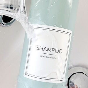 sage green pump dispenser bottle held under running tap to show white shampoo label applied as waterproof, label is cream with SHAMPOO written central in square label with thin line boarder around edge with HOME COLLECTION written smaller underneath