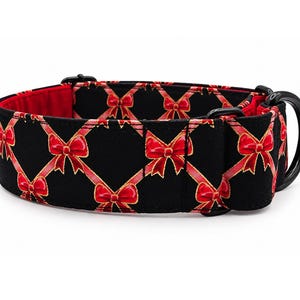 May include: A black pet collar featuring a repeating pattern of red bows connected by thin red ribbons in a diamond grid. The collar has a bright red interior lining, black metal hardware, and a sturdy black D-ring for attachment.