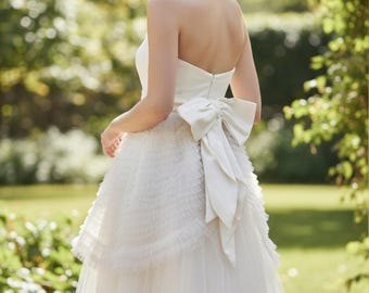 Vestido vintage sin tirantes de los años 50 con capas de tul y un gran lazo de satén.