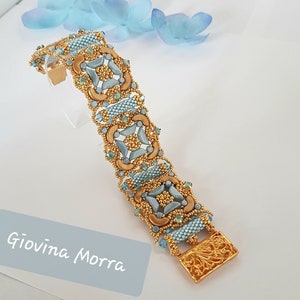 May include: A gold and blue beaded bracelet with a geometric design. The bracelet has a clasp with a floral pattern.