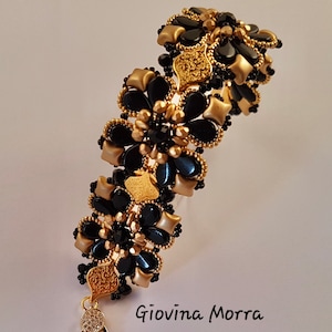May include: A black and gold beaded bracelet with a floral design. The bracelet has a clasp closure and is made with small, round beads.