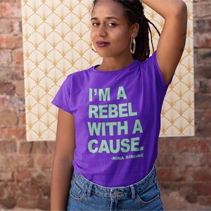 May include: A purple t-shirt with a light green graphic that reads "I'm a rebel with a cause - Nina Simone".