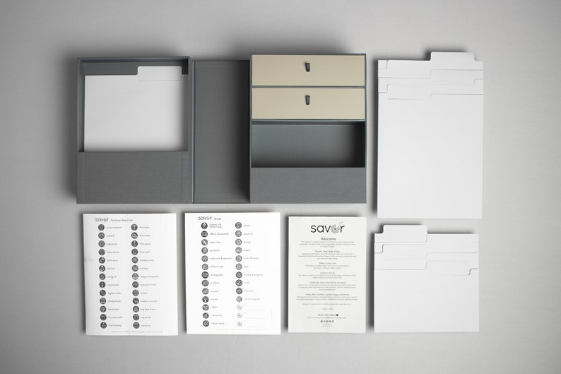 May include: A gray box with two drawers and a compartment for storing recipe cards. The box is open and the drawers are pulled out. There are several sheets of paper with recipe categories and a welcome letter from the company "savor".