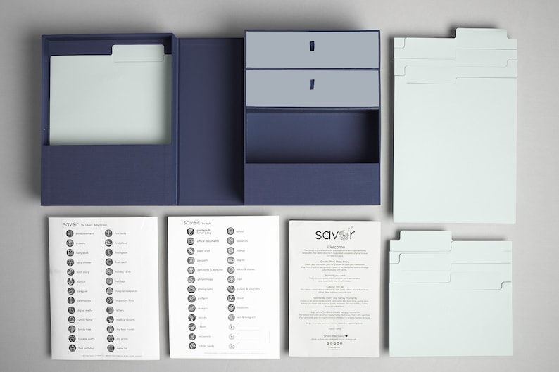 May include: A blue recipe box set with dividers, index cards, and instructions. The box has a drawer for storing recipe cards. The set includes a welcome guide and two sheets of recipe icons.