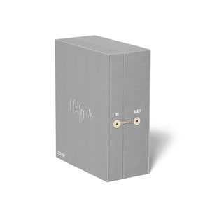 May include: A gray box with the text "Harper" and "The Vault" printed on it. The box has a brown string tied around it.