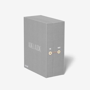 May include: A gray box with the text "Adelaide" and "The Vault" printed on it. The box is tied with a string.
