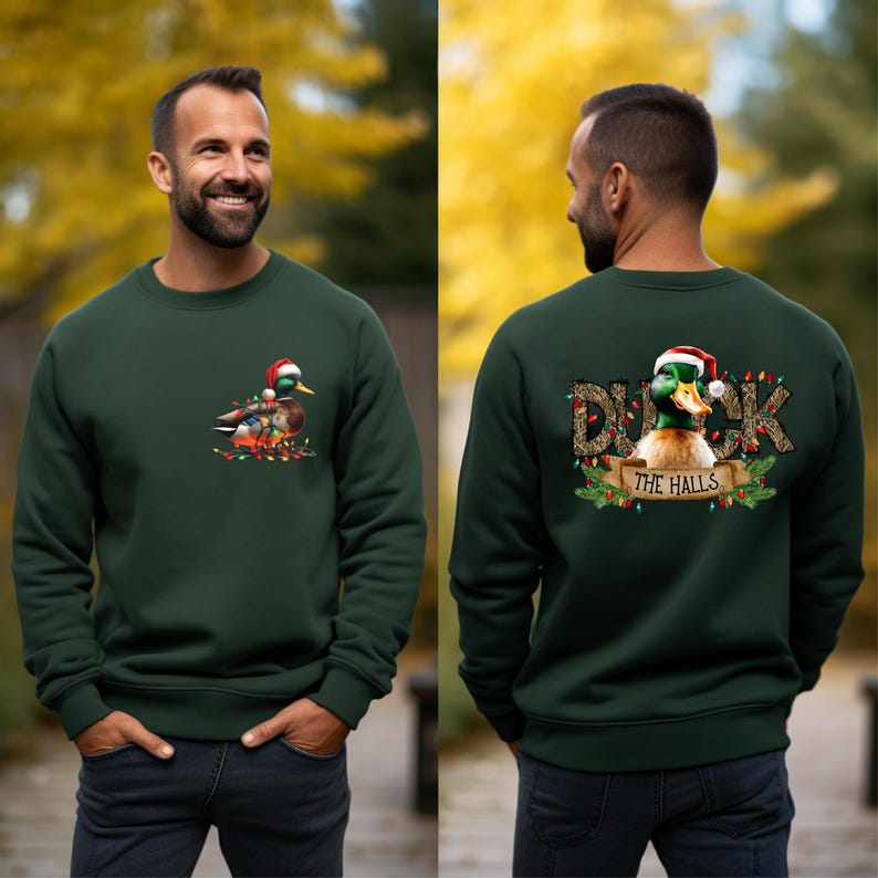 May include: A dark green sweatshirt with a Christmas duck design. The front of the sweatshirt features a duck wearing a Santa hat and surrounded by Christmas lights. The back of the sweatshirt features the text "Duck the Halls" with a duck wearing a Santa hat and surrounded by Christmas lights.