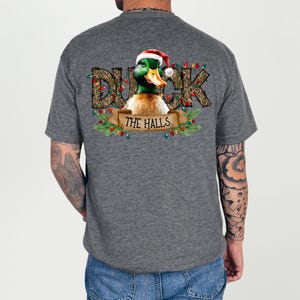 May include: A gray t-shirt with a Christmas-themed design featuring a duck wearing a Santa hat and the text "Duck the Halls".