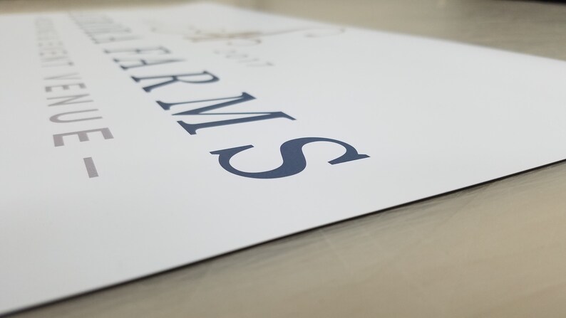 May include: A white sign with the text "The Farm" and "Wedding Venue" in a dark blue font.