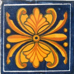 May include: A blue and orange tile with a stylized floral design. The tile has a white border and is made of ceramic.