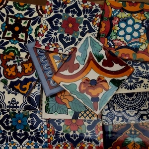 May include: A collection of colorful ceramic tiles with intricate floral patterns in shades of blue, red, orange, and yellow. The tiles are arranged in a random pattern, creating a visually appealing mosaic.
