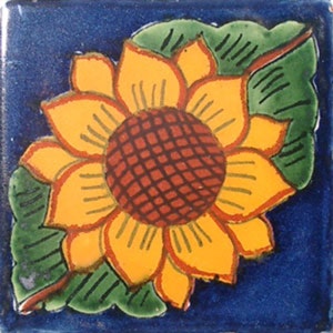 May include: A yellow sunflower with a red center and green leaves on a blue background. The sunflower is in the corner of the tile.