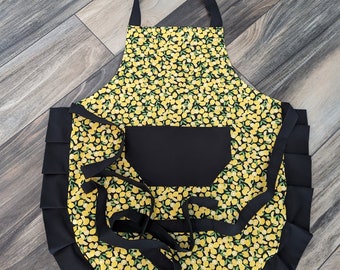 Adult apron. Woman's apron. Bright yellow lemons on main. Black on pocket, ties and frills.