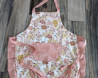Adult apron. Woman's apron. Pink and yellow muted floral on main. Blush pink on pocket ties and frills.