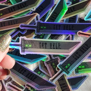 May include: A stack of iridescent holographic stickers featuring a sword with the text "GET HELP." The stickers are arranged in a random pattern and have a rainbow sheen.