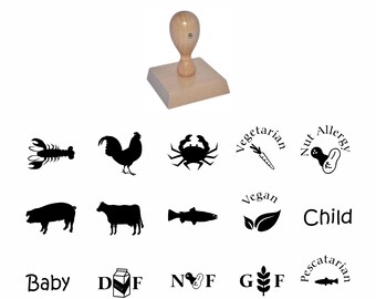 May include: A set of 10 wooden rubber stamps with various allergy and dietary icons and text. The icons include a lobster, a rooster, a crab, a carrot, a peanut, a pig, a cow, a fish, a leaf, and a milk carton. The text includes "Vegetarian", "Nut Allergy", "Vegan", "Child", "Baby", "DF", "NF", "GF", and "Pescatarian".