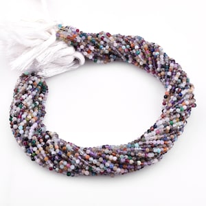 May include: A strand of multi-colored gemstone beads, including amethyst, rose quartz, and green aventurine. The beads are small and round, and the strand is approximately 16 inches long.