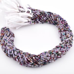 May include: A strand of multi-colored gemstone beads, including amethyst, rose quartz, and other semi-precious stones. The beads are small and round, and the strand is approximately 16 inches long.
