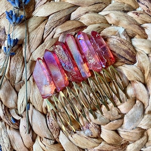 May include: Set of six gold hair combs with iridescent red crystal accents. The combs are arranged in a row on a woven surface.