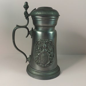 Tin beer mug with a lid depicting the coat of arms with knight&#39;s armor. Germany.