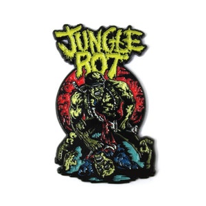 May include: A yellow and black enamel pin featuring a green monster with a red background. The monster is holding a knife and is attacking another monster. The text "Jungle Rot" is above the monster.