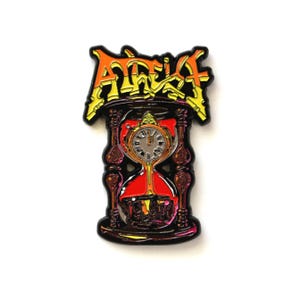 Puede incluir: Pin esmaltado con un reloj de arena estilizado con una esfera de reloj, sobre un fondo rojo vibrante. El pin tiene un borde negro y la palabra "ATHEIST" en letras naranjas y amarillas.