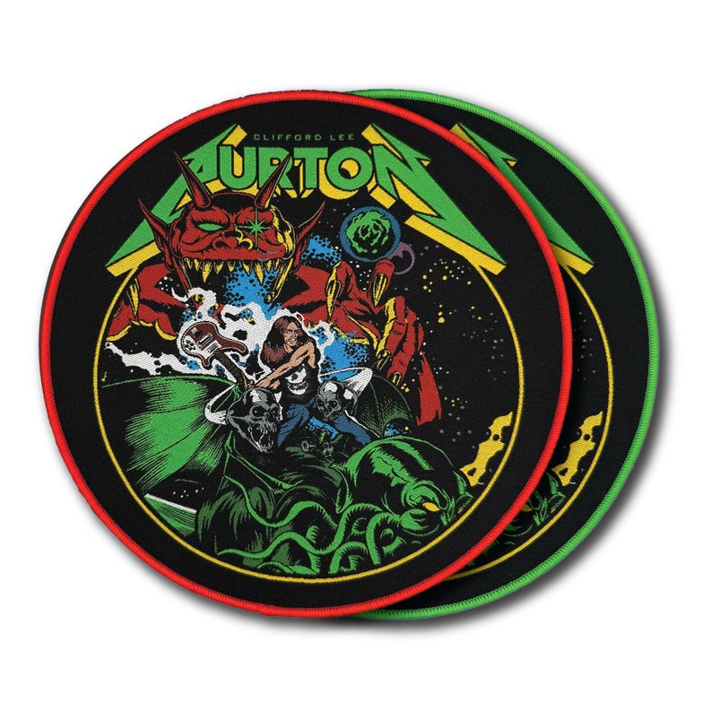 May include: Two circular embroidered patches featuring a graphic illustration of a red demon and a guitarist. The text CLIFFORD LEE BURTON is printed in green at the top. The design includes green tentacles, skulls, and a starry black background.