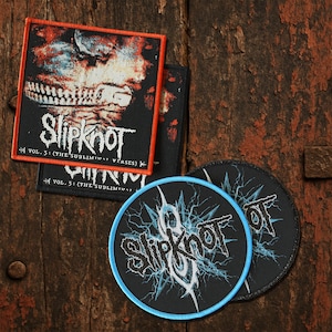Puede incluir: Un conjunto de parches de la banda Slipknot. Los parches presentan el logotipo de la banda y arte del álbum, con un parche cuadrado con un borde naranja y el texto "VOL. 3: (THE SUBLIMINAL VERSES)". Los parches redondos tienen un borde azul.