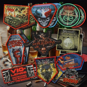Op de afbeelding: Een verzameling geborduurde patches met logo's en artwork van heavy metal bands. Ontwerpen omvatten schedels, demonen en bandnamen zoals Sepultura en Exodus. De patches zijn in verschillende vormen en kleuren, met rood, zwart en blauw prominent aanwezig.
