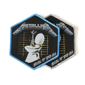 May include: Two hexagonal embroidered patches with black backgrounds. Each features the Metallica logo, a graphic of a hand holding a sword inside a toilet, a yellow grid, and the text "METAL UP YOUR ASS" in white. One has a blue border, one silver.