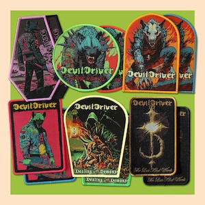 May include: A collection of embroidered fabric patches featuring the band name DevilDriver. Designs include a wolf-like creature, a hooded figure, and the text Strike and Kill, Dealing with Demons, and The Last Kind Words in various shapes.